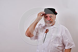 Courteous senior man looking serious is tipping his hat