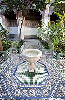 A courtyard with a fountain and mosaic tiled floor in a palace in Morocco