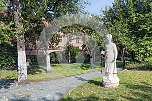 Courtyard garden with statue and old historic houses of beguinage in Antwerp, Belgium