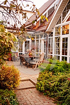 the courtyard of the house with a large wooden table decorated in autumn style.