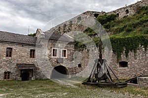 The courtyard of the medieval fortress with the idle old trebuchet.