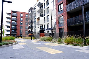 Courtyard of modern apartment buildings district with sidewalk and green grass