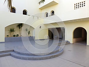 Courtyard with white walls and marble floor and podium