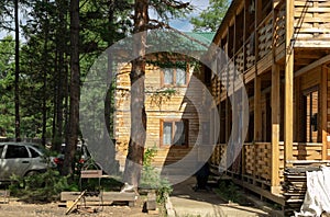 Courtyard of wooden house in countryside forest, traditional rest in cozy rural cabin, concept of unity with nature