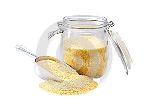 Couscous in metal scoop and  in glass storage jar isolated on white background