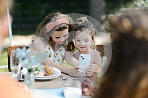 Cousins taking a selfie at a family garden party. Family reunion at garden barbecue party.