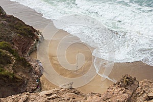 Cove on Almagreira beach with a Sunday fisherman in the central Portuguese Western coast, in Peniche