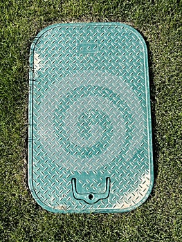 Cover of a manhole on the grass area