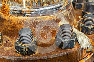 The cover of the old rusty heat exchanger covered with the same rusty bolts and nuts