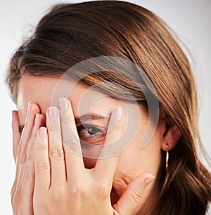 Cover, scary and woman with hands on eye to hide from surprise or fail in portrait on studio background. Girl, worry and