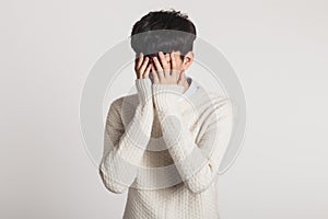 Cover your face with your hands, Studio portrait of a sad Asian young man