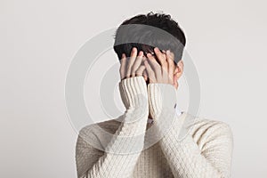 Cover your face with your hands, Studio portrait of a sad Asian young man