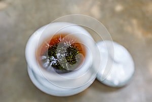 Covered-bowl tea with tree reflection