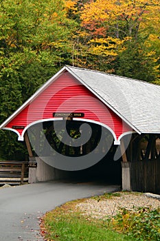 A covered bridge is surrounded by New England fall foliage