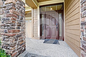 Covered entrance porch boasts front door with ornate sidelights