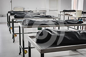 Covered human corpses on tables in a morgue / mortuary waiting for identification, autopsy, burial or cremation. Taken in Armenia