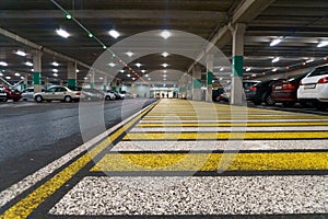 Covered parking for cars. Underground parking. Road markings on wet asphalt. Pedestrian crossing, zebra crossing. Selective focus