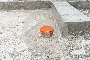 Covered sewer pipe protruding from the foundations of the house being built.