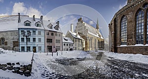 Covered in snow street in historic city center in Riga. Historic houses near Saint Peter`s church in winter in Riga, Latvia
