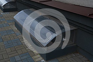 Covered transparent basement window at sidewalk level.