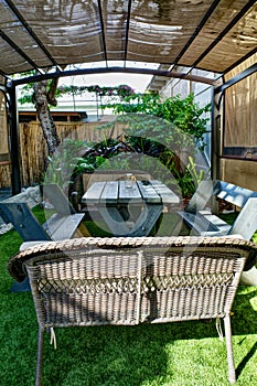 Covered Tropical Outdoor Sitting Area With Table and Benches