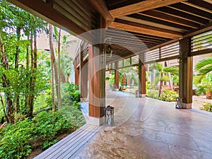 Covered tropical walkway surrounded by gardens