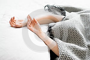 Covered woman with protruding hands out of blanket