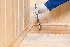 Covering the wooden surface of the floor with a brush and dark varnish