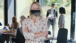 COVID-19 as new normal. Portrait of young happy gen-z 20s blonde business woman in face mask at light office slow motion