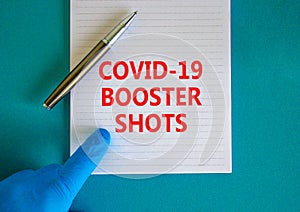 Covid-19 booster shots vaccine symbol. White note with words Covid-19 booster shots, beautiful blue background, doctor hand and