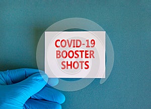 Covid-19 booster shots vaccine symbol. White note with words Covid-19 booster shots, beautiful blue background, doctor hand in