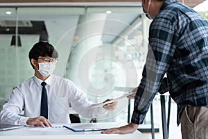 Covid-19 concept two businessmen wearing a mask planning for new project during Coronavirus outbreak COVID-19