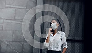 Covid-19 or Corona Virus Situation in Business Concept. Business Woman with Medical Mask Looking Up while Using Smartphone. Face