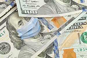 COVID-19 coronavirus in USA, 100 dollar money bill with Franklin in surgical face mask, macro. COVID affects global stock market