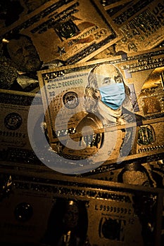 COVID-19 coronavirus in USA. Hundred golden dollar money bill with face mask.