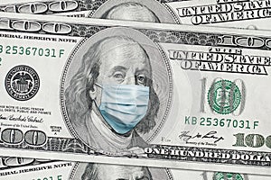 COVID-19 coronavirus in USA. Hundred golden dollar money bill with face mask.