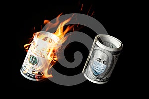 COVID-19 coronavirus in USA. Roll of hundred dollars money bill with face mask and in fire.