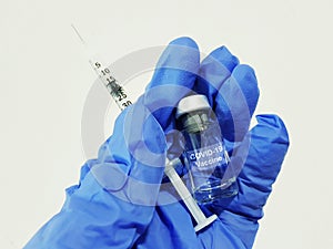 Covid-19 Coronavirus Vaccine. Hand glove, drug vial and syringe