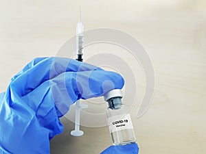 Covid-19 Coronavirus Vaccine. Hand glove, drug vial and syringe