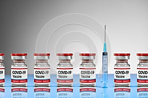 Covid-19 Coronavirus Vaccine red vials in a row with a syringe