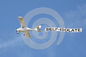 Covid-19 disease pandemic epidemic virus aeroplane banner public notice self isolate sign sky skywriter plane warning