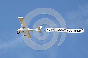 Covid-19 disease pandemic epidemic virus aeroplane banner public notice self isolate sign sky skywriter plane warning