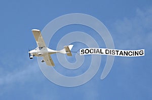 Covid-19 disease pandemic epidemic virus aeroplane banner public notice self isolate sign sky skywriter plane warning