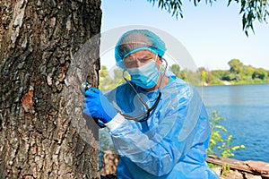 COVID-19. Doctor in medical facial mask hold stethoscope and exam tree patient.