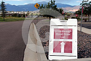 Covid-19 Drive Through Blood Draw Testing Lab Sign with Arrow and mountain