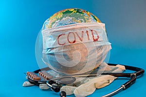 Covid-19 Global pandemic of the corona virus. Globe in a medical mask with gloves and stethoscope. Health time concept