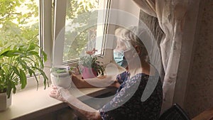 The Covid-19, health, safety and pandemic concept - senior old lonely woman sitting near the window