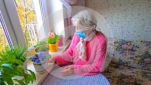The Covid-19, health, safety and pandemic concept - senior old lonely woman sitting near the window