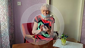 The Covid-19, health, safety and pandemic concept - senior old lonely woman sitting with phone