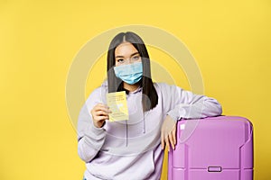 Covid-19 and healthcare concept. Tourism. Young asian woman tourist shows her health passport, coronavirus international